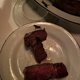Ribeye at the bottom of plate. Filet side of the porterhouse, in the middle.  Strip side of the porterhouse at top of plate.