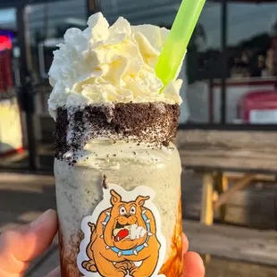 a hand holding a cup of ice cream