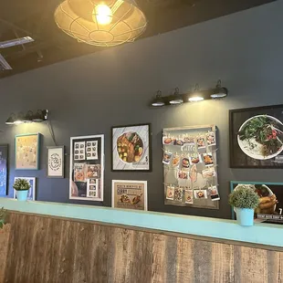 a restaurant counter with pictures on the wall