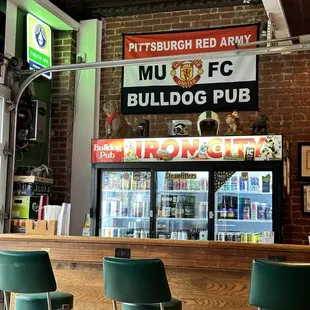 a bar with two green chairs