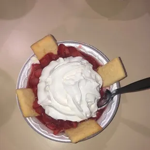 a bowl of strawberries and whipped cream