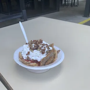 a waffle topped with whipped cream and pecans