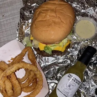 Bacon cheeseburger with onion rings and their hot sauce