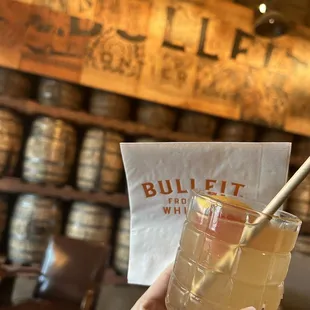 Elderflower Fizz cocktail drink and lounge area barrel wall.