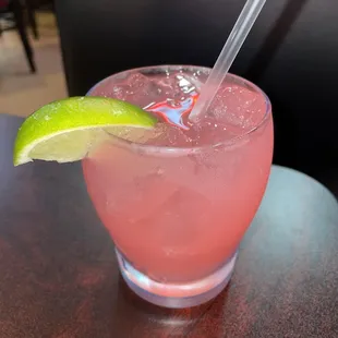 a pink drink with a lime wedge