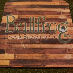 a wooden sign with the word bullfrog creek brewing