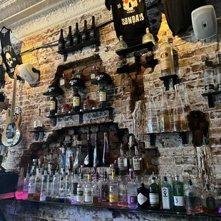 a brick wall with bottles of liquor on it