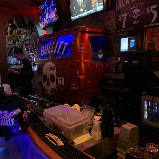 a bar with a bar top and neon signs