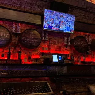 a bar with beer barrels and a television