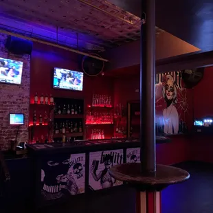 a bar with a bar stool and televisions