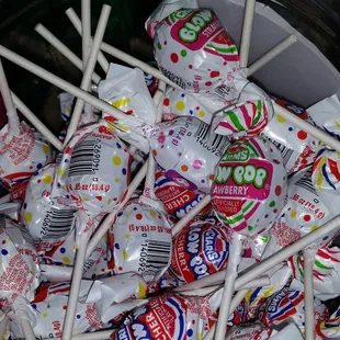 a bowl full of candy lollipops