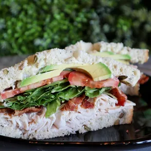 a sandwich with lettuce, tomato, and avocado