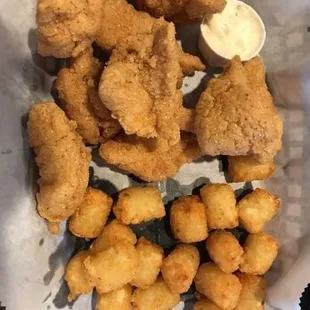 a basket of fried shrimp and tater tots