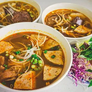 three bowls of soup with meat and vegetables