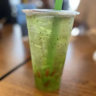 a green drink in a plastic cup