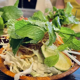 Fresh herbs and veggies: mint, banana blossom slivers, cabbage, lime and bean sprouts.