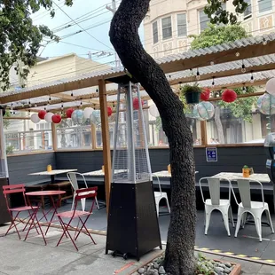 a restaurant with tables and chairs under a tree