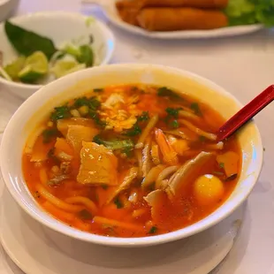 a bowl of soup with a red spoon