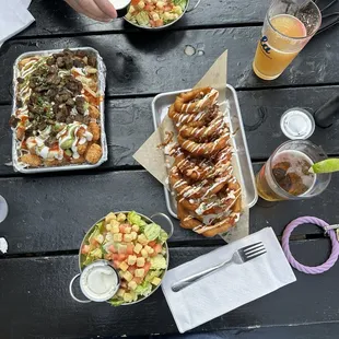 Side salads, onion rings, half taters with half fries tops with sauces and carne asada