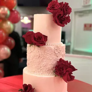 a wedding cake with red roses