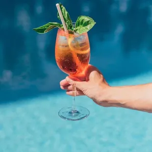 a person holding a glass of cocktail