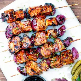a platter of grilled meat skewers