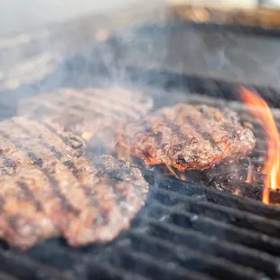 a hamburger being cooked on a grill