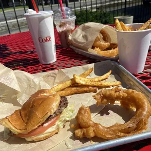 Burger, fries, and onion rings on the patio.