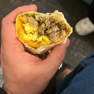 a hand holding a burrito