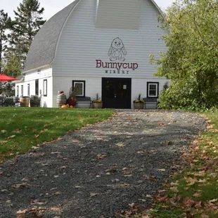 a white barn with a red awning