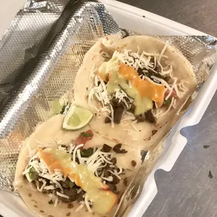 two tacoss in a container