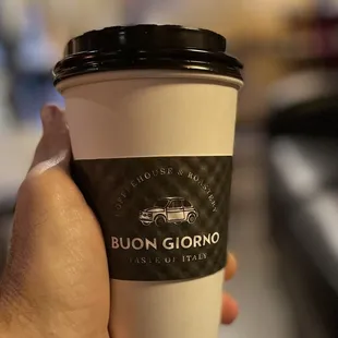 a hand holding a coffee cup