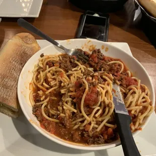 a bowl of spaghetti and bread