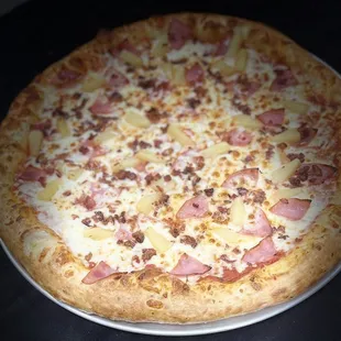 a pizza with ham and pineapple toppings