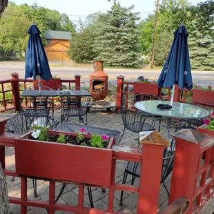 a patio with tables, chairs, and umbrellas