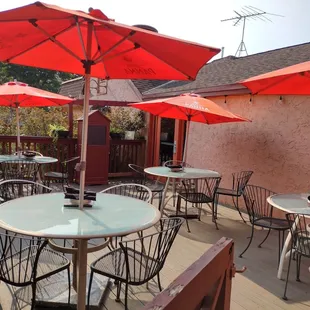 a patio with tables and umbrellas