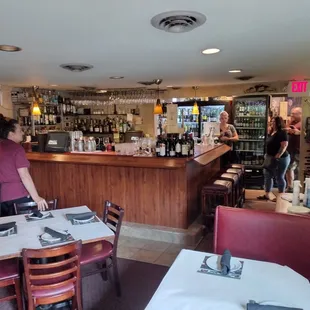 a woman standing at the bar of a restaurant