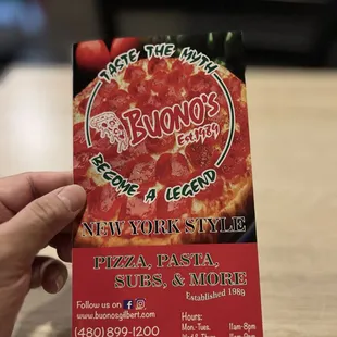 a hand holding a pizza