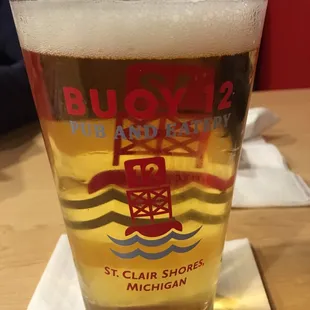a glass of beer on a coaster