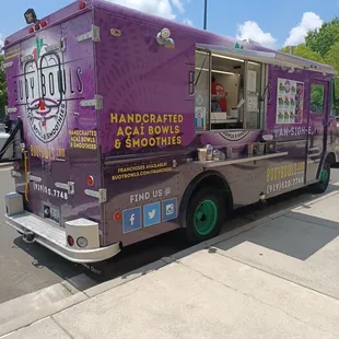 a purple food truck parked on the side of the road