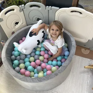 My daughter in the ball pit with balls colored to match my theme
