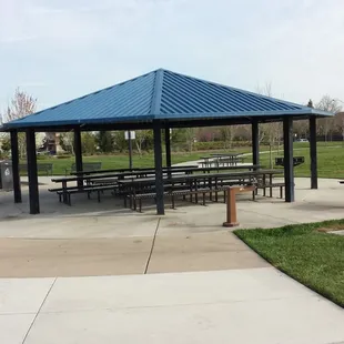 Tables and bbq pit under shade