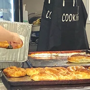 a person putting a pastry on a baking sheet