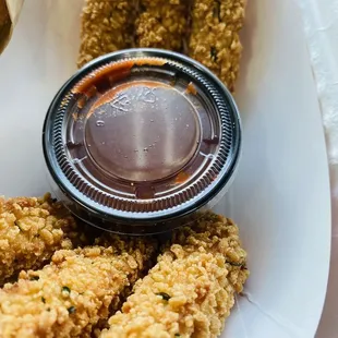 a basket of fried chicken with dipping sauce