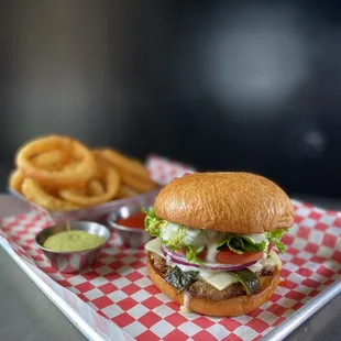 a burger and onion rings on a tray