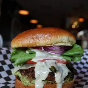 Hold My Bun: Swiss cheese, spring mix, tomato, caramelized onions, avocado, and avocado cream.