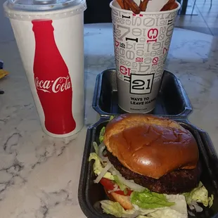 Impossible vegan plant based Impossible,patty, onions, lettuce, Roma tomato, toasted whole wheat bun. Sweet potato fries and Coke.