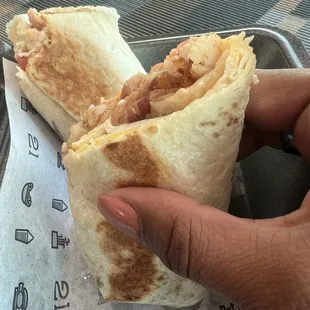 Breakfast Burrito eggs, bacon, cheese, tomato, hash browns, secret sauce