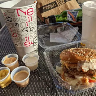 Veggie burger with fries and lots of sauces and a shake