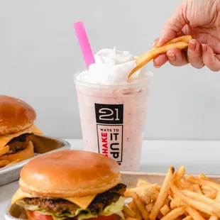 a person taking a bite out of a burger